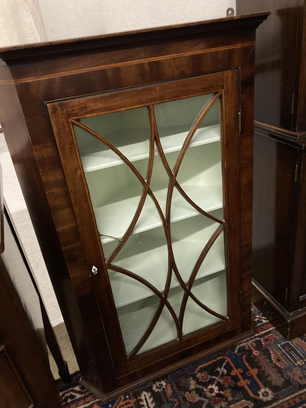 A George III mahogany hanging corner cupboard with glazed door, width 74cm, depth 39cm, height 110cm